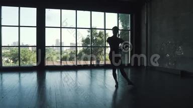 窗户背景上芭蕾舞演员的剪影。 男人优雅而美丽地在古典芭蕾中跳舞
